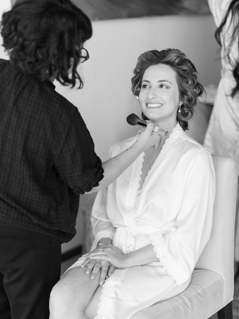 black and white photo of bride getting her makeup done