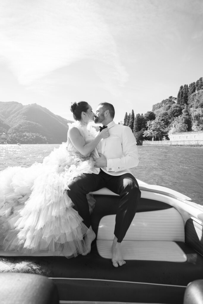 Bride and groom kiss on a boat in Lake Como for their wedding